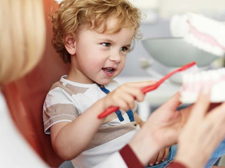 little boy learning how to brush his teeth