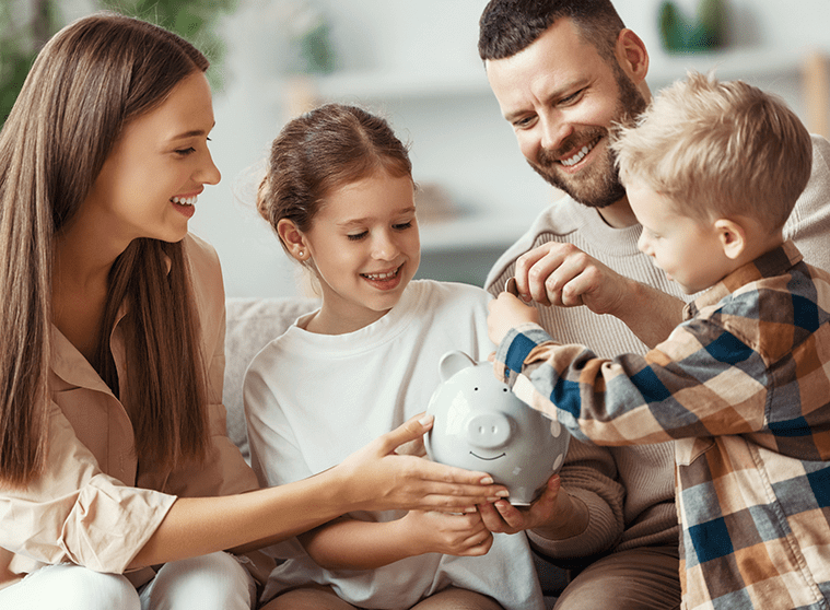 parents helping their kids add coins to a piggy bank