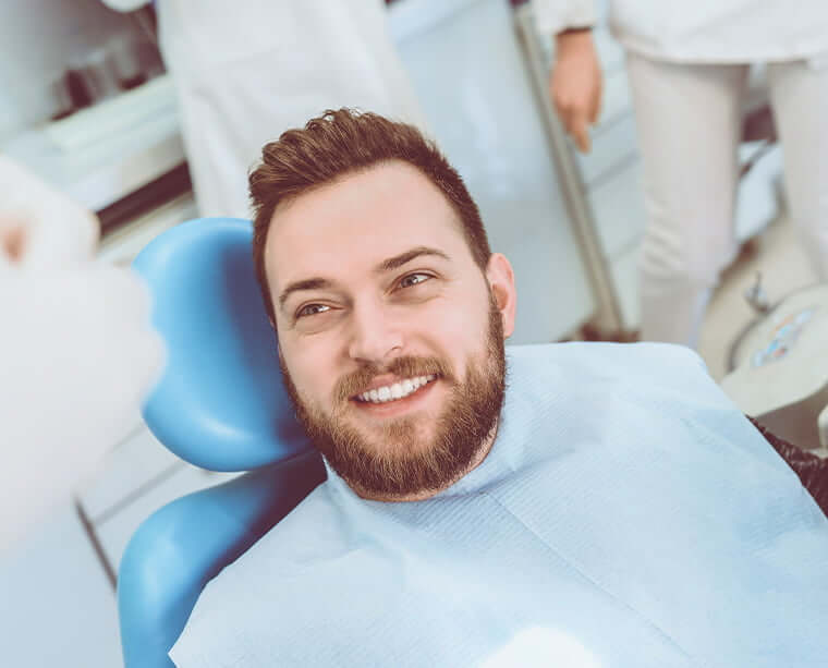 smiling man sitting in a dental chair