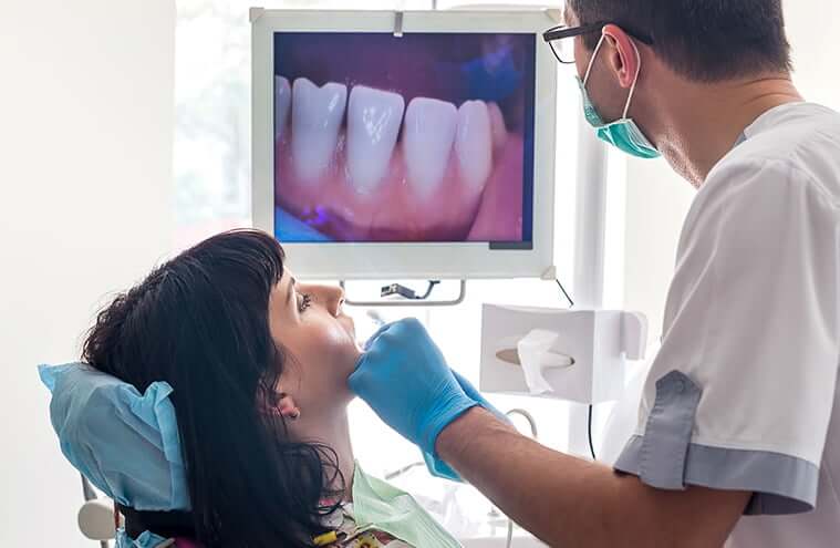 dentist looking at a closeup image of a patient's teeth