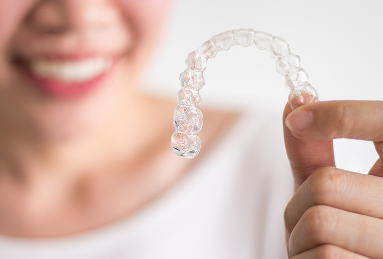 woman holding invisalign